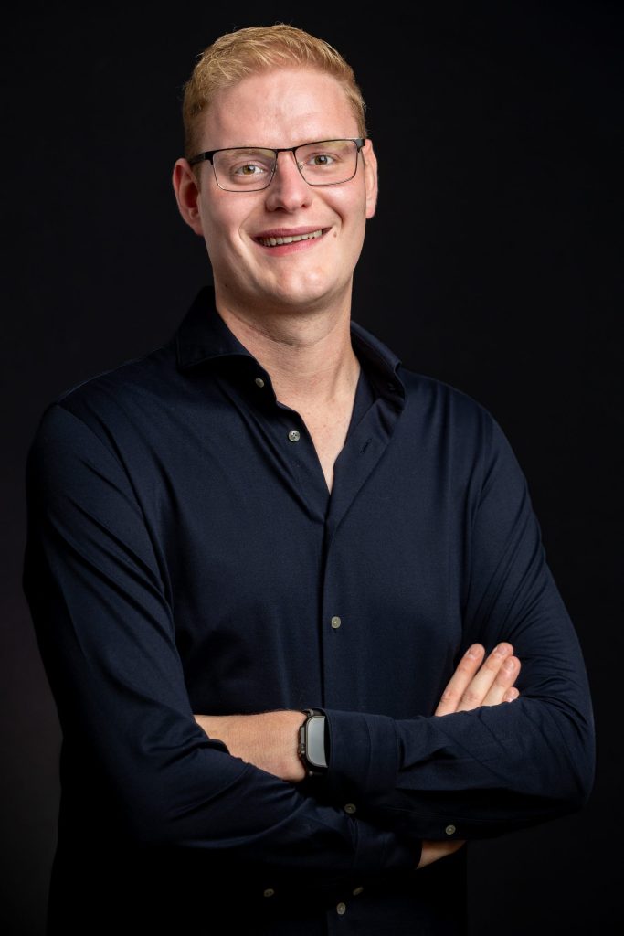 Portret van fotograaf Jurgen Versteeg in donker overhemd tegen een donkere achtergrond